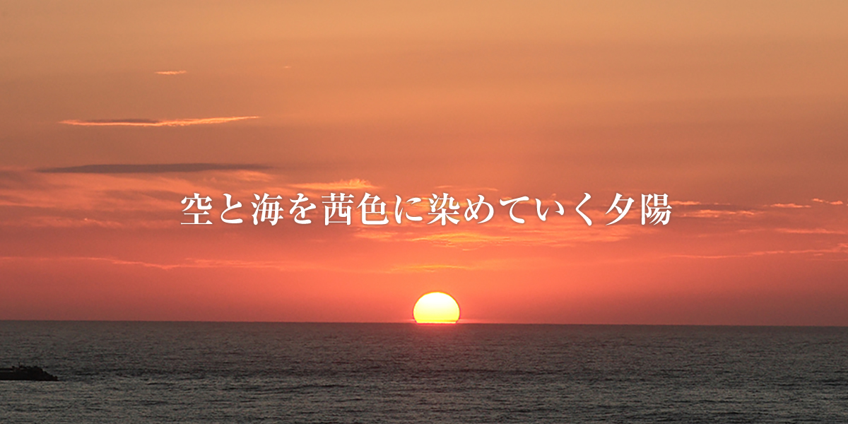 空と海を茜色に染めていく夕陽